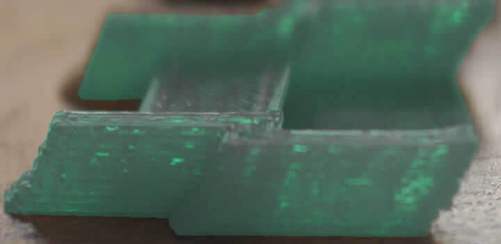 foto de uma peça verde impressa com problema de inclinação em impressora 3d com fialmento 3d